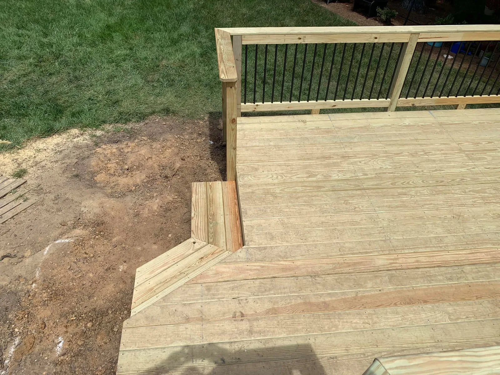 Completed deck stairs with black balusters after cleanup