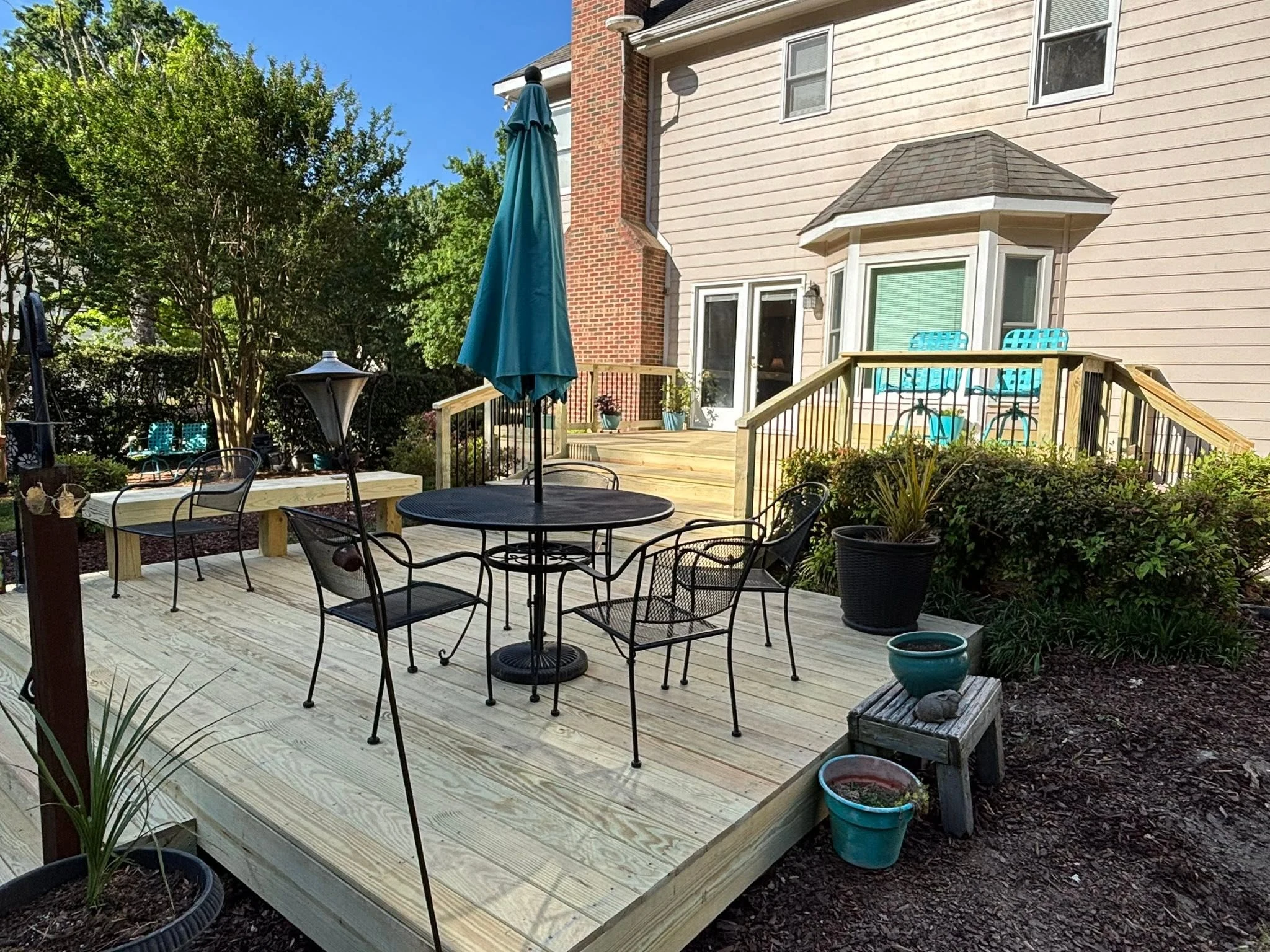 Multi-level custom wood deck with wide stairs and lower patio dining area