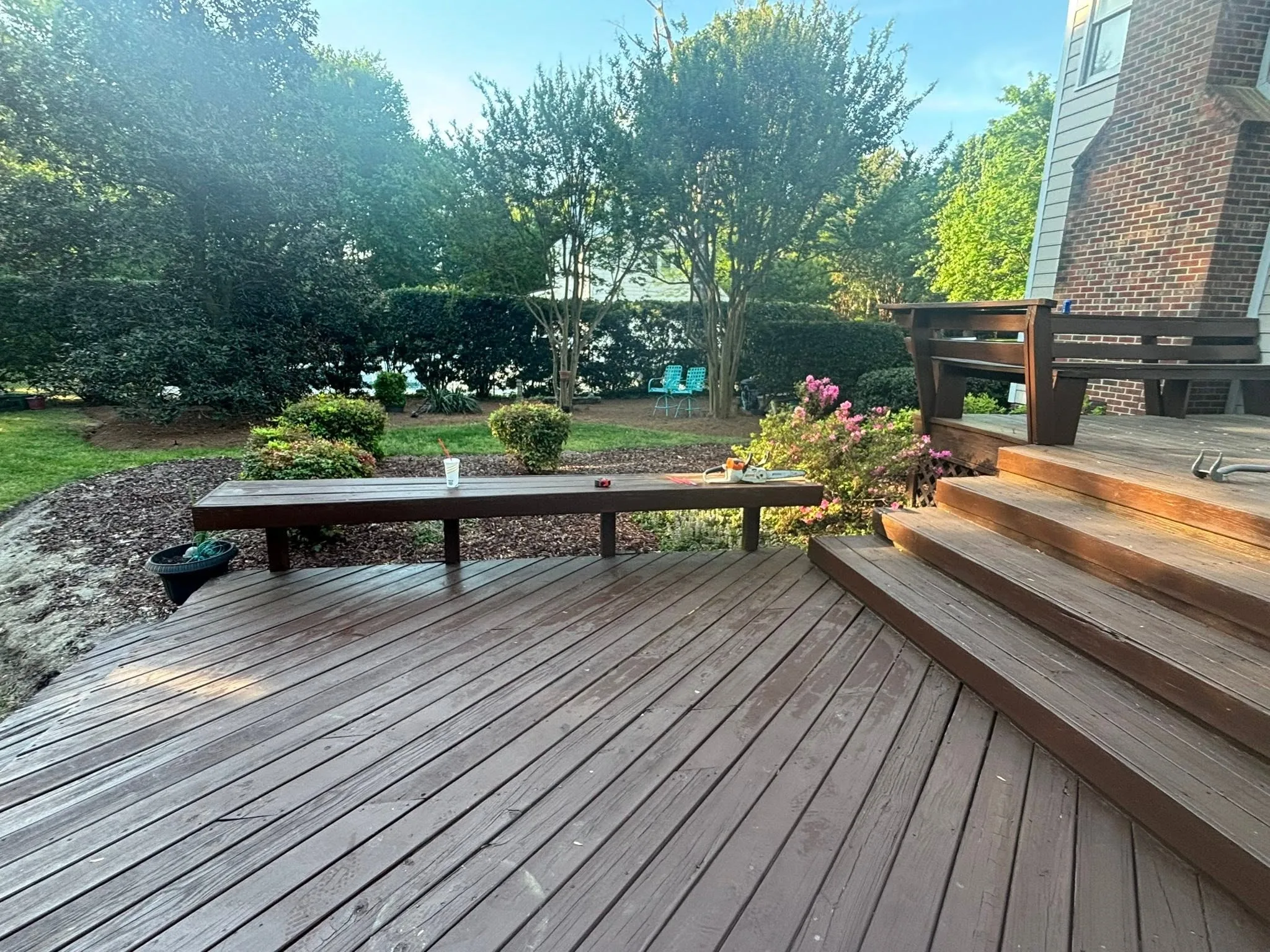 Stained wood deck with wide steps built by Deck By Deck